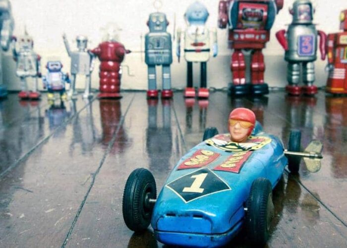 Une voiture miniature devant des robots jouets vintage