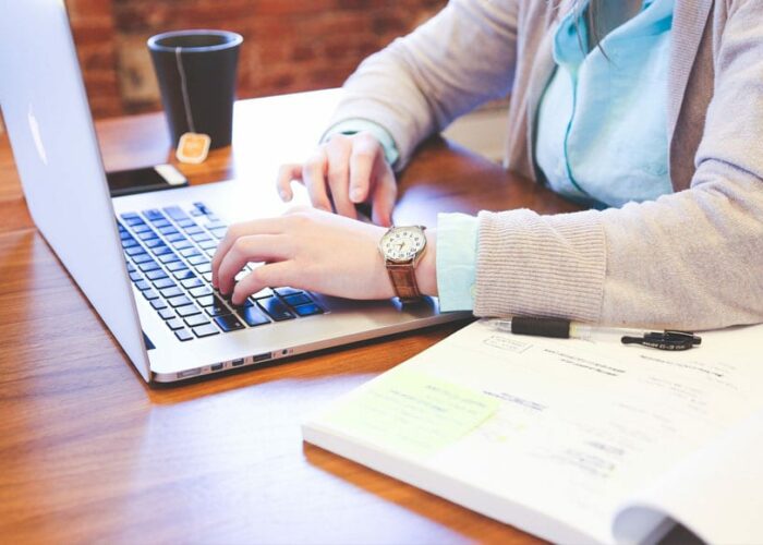 Une femme en train d'écrire sur le web avec un PC portable