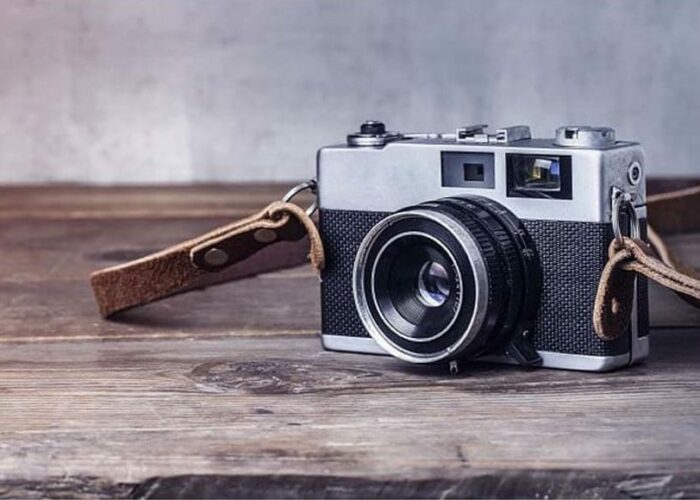 Un appareil photo vintage gris sur une table en bois